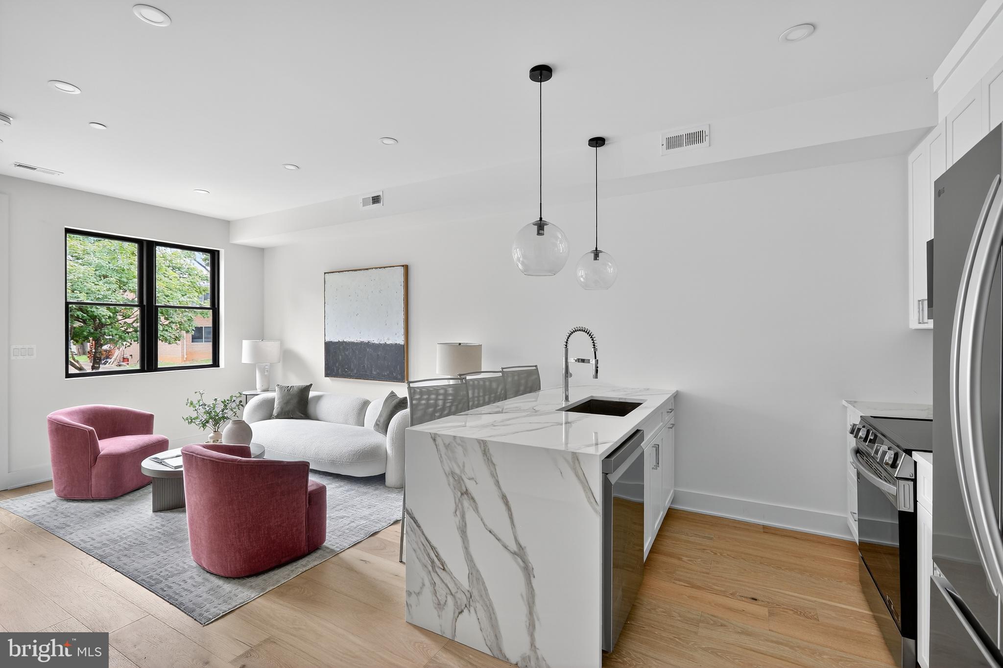 a living room with furniture a window and a wooden floor