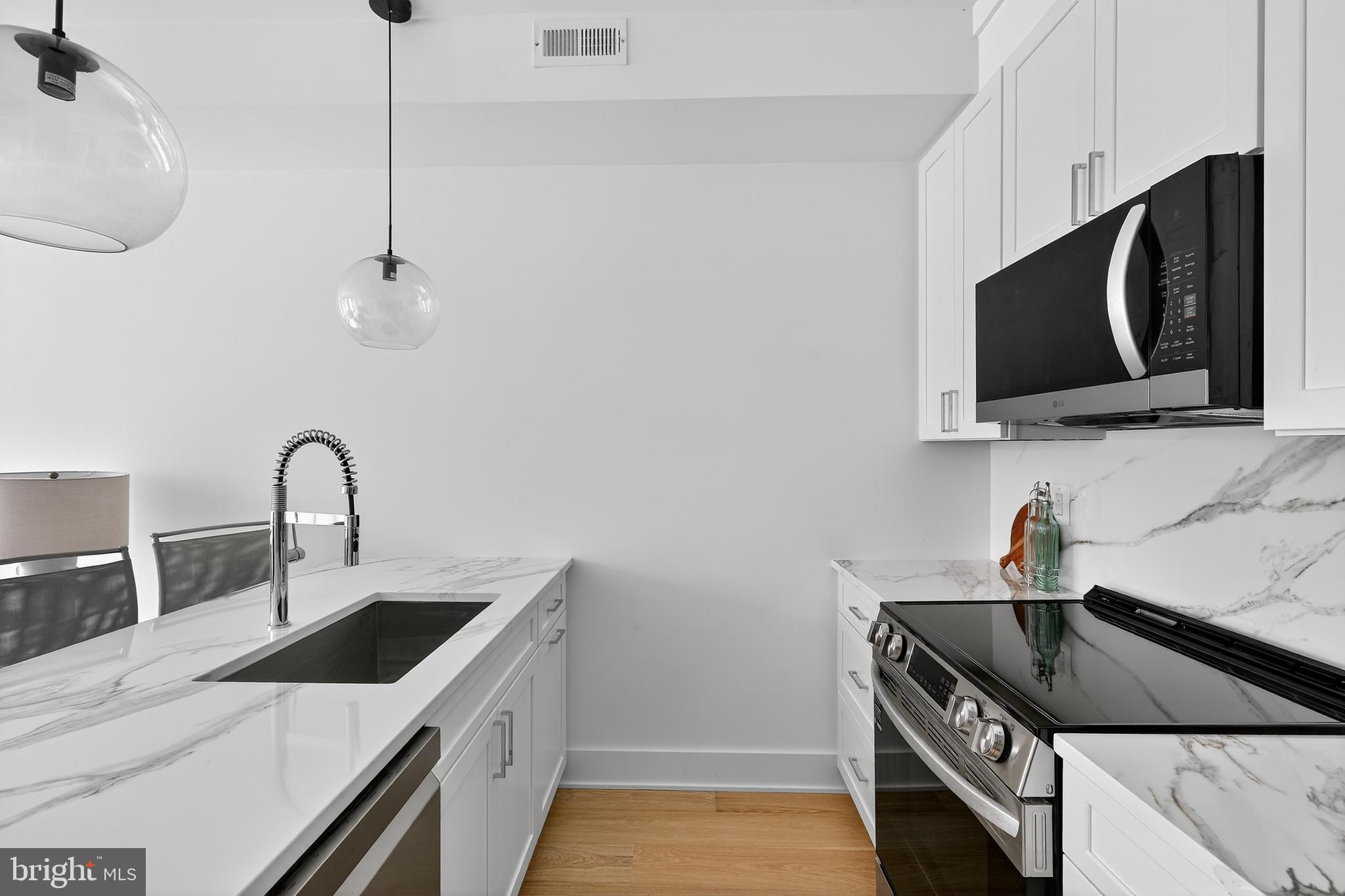 828 21st Street Northeast, Unit 2 Washington, DC 20002 - Photo 9 of 27 a kitchen with stainless steel appliances a sink a stove a microwave and cabinets