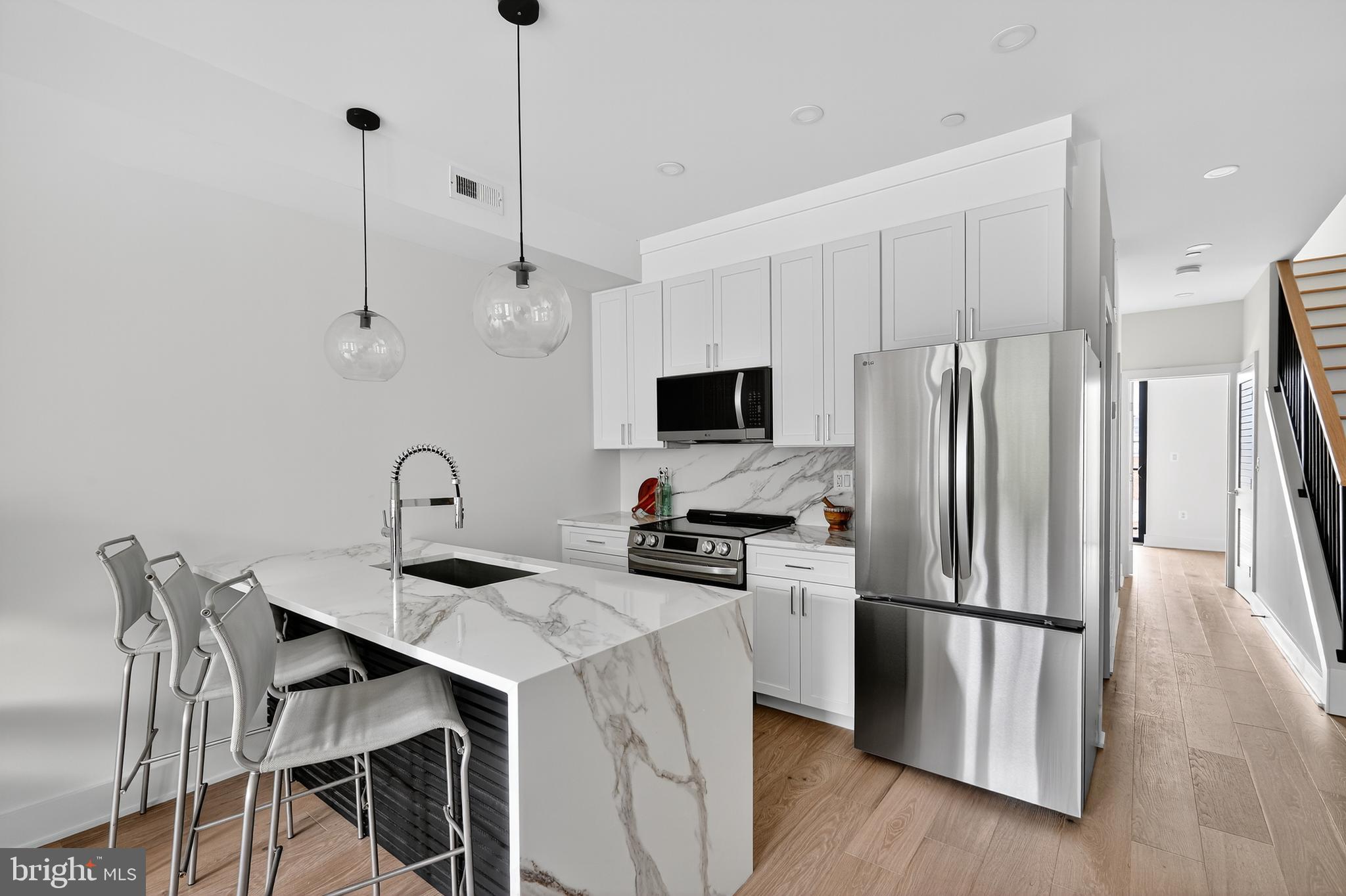 828 21st Street Northeast, Unit 2 Washington, DC 20002 - Photo 10 of 27 a kitchen with stainless steel appliances a refrigerator a sink a stove a dining table and chairs