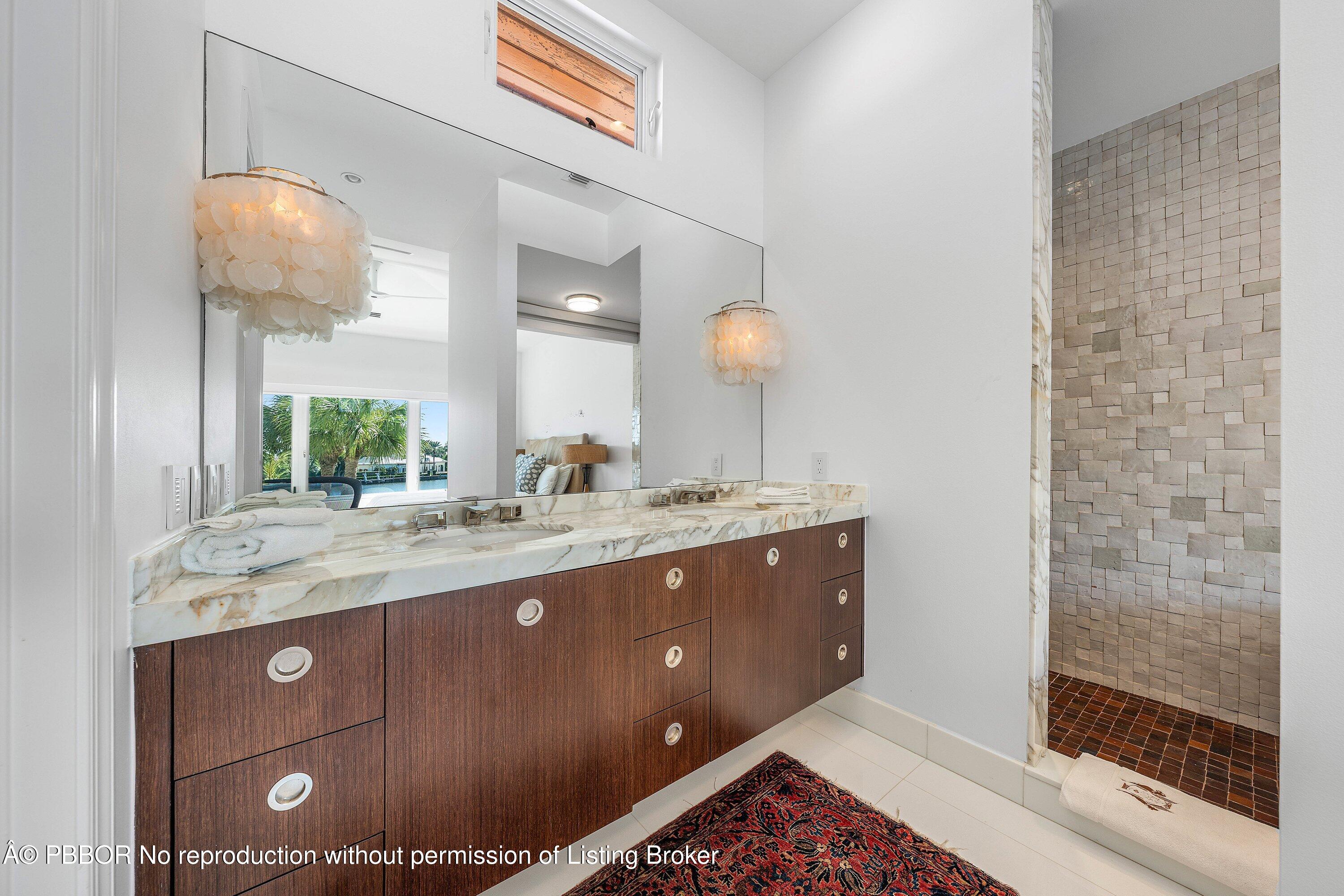 50 Spoonbill Road Lantana, FL 33462 - Photo 27 of 38 a bathroom with a sink a large mirror and shower
