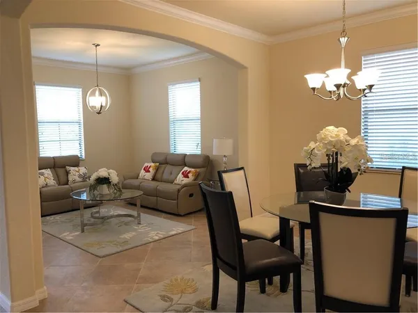 a living room with furniture a chandelier and a window