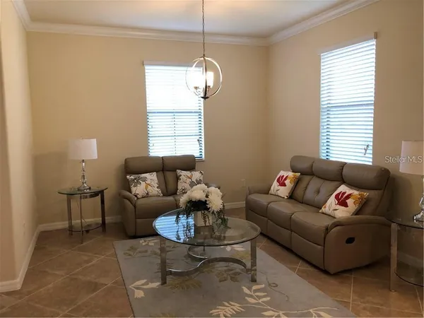 a living room with furniture a dining table and a window