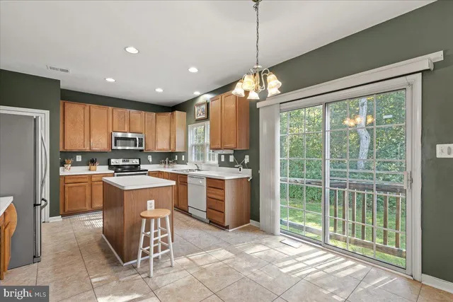 a open kitchen with stainless steel appliances granite countertop a refrigerator a sink a stove and cabinets