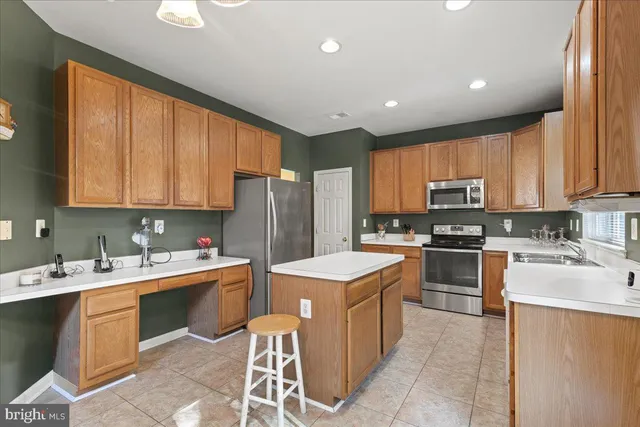 a kitchen with a sink a counter top space stainless steel appliances and cabinets