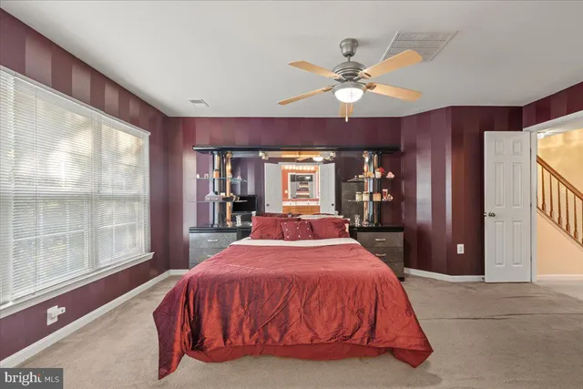 a bed sitting in a spacious bedroom next to a window