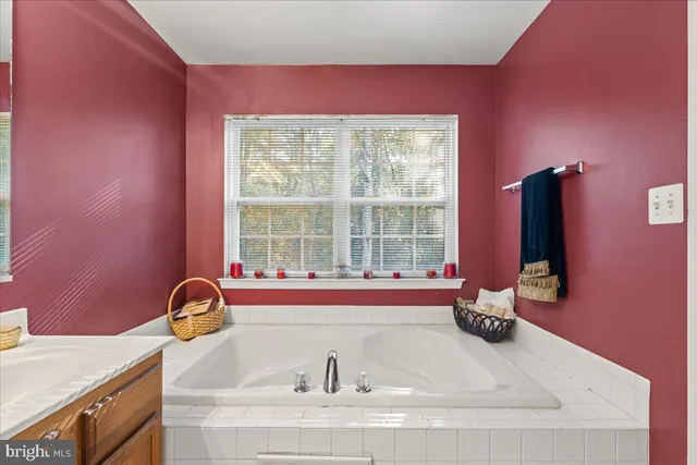 a bathroom with a granite countertop tub and a sink