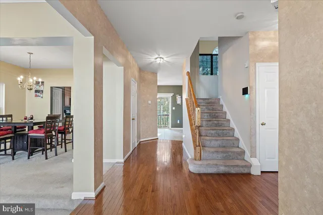 a view of a hallway with dining room and wooden floor