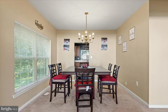 a view of a dining room with furniture and a chandelier