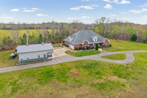 a view of a house with pool and a yard