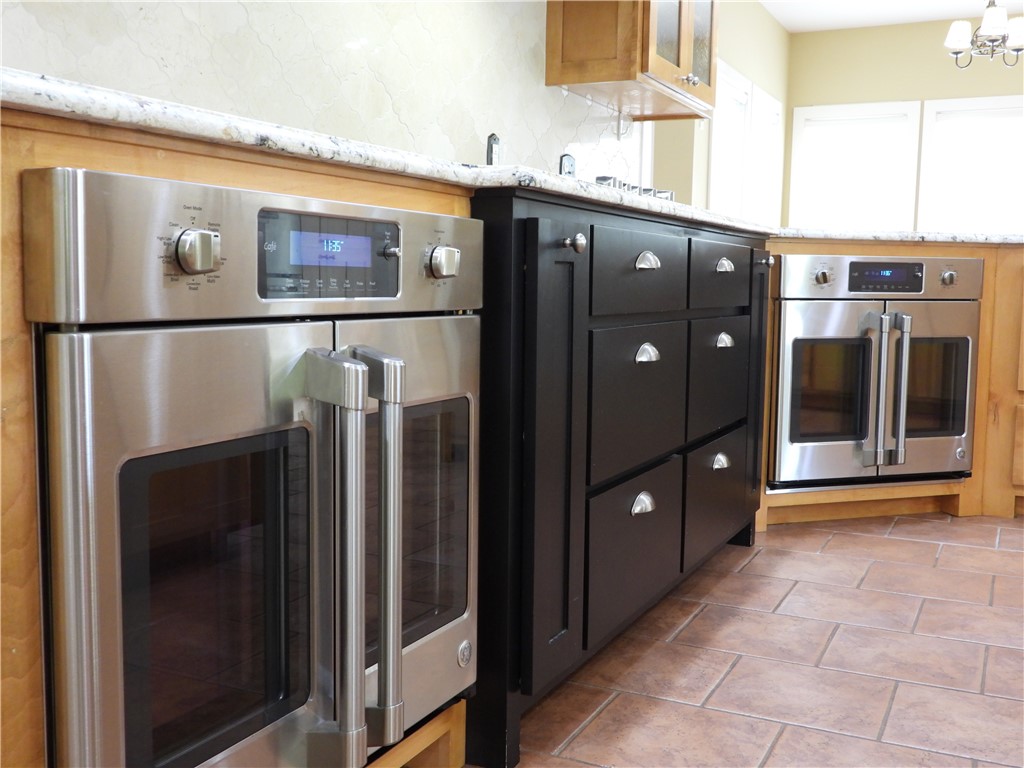 19489 Oak Circle Springdale, AR 72764 - Photo 5 of 58 Stainless steel built-in double oven with professional-style handles, integrated into light wood-finish cabinetry