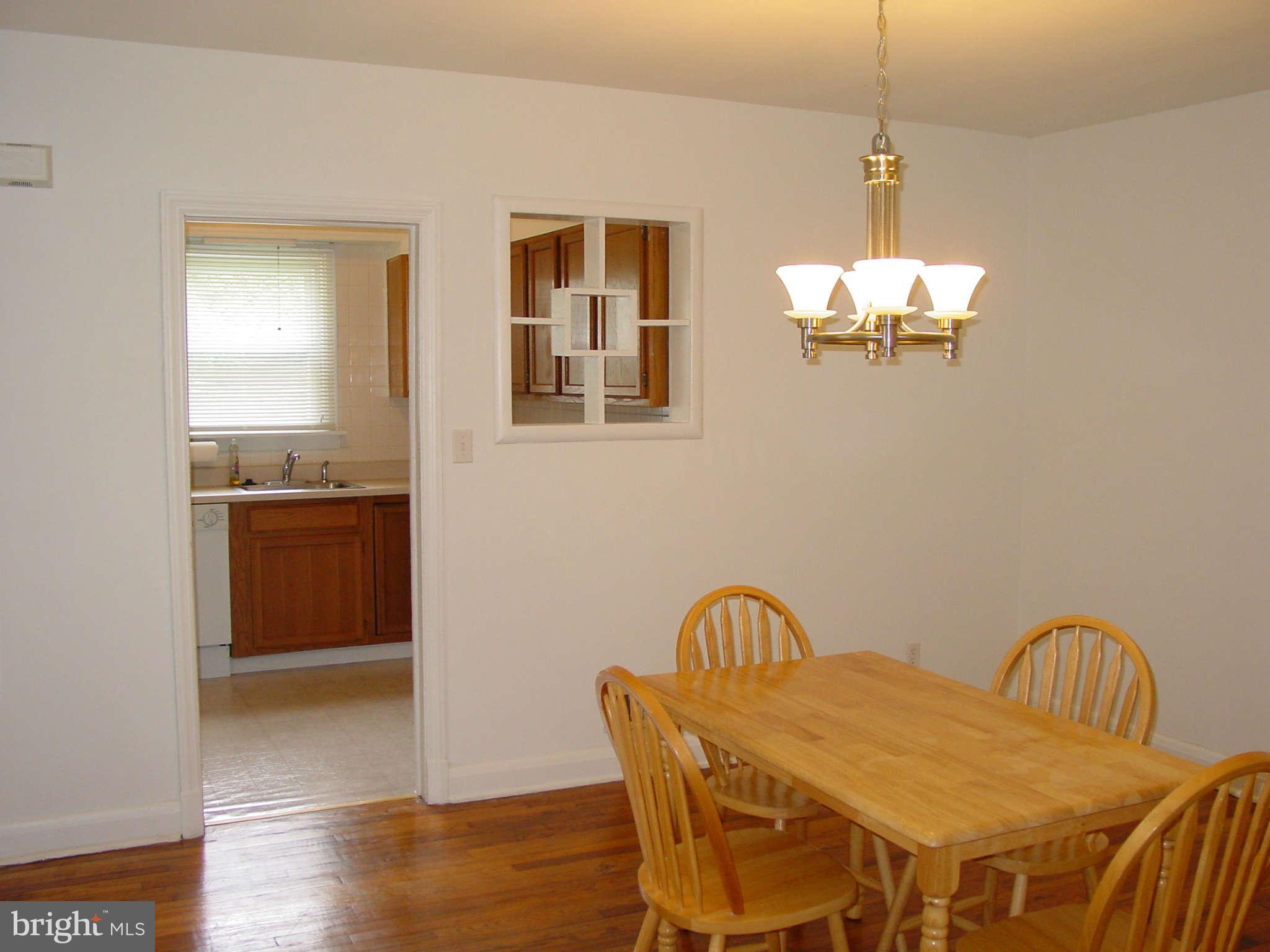 7903 Bon Air Road Baltimore, MD 21234 - Photo 4 of 17 a view of a dining room with furniture a chandelier and wooden floor