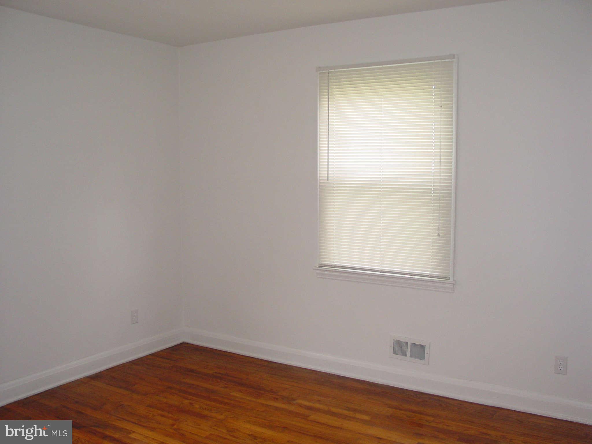 7903 Bon Air Road Baltimore, MD 21234 - Photo 8 of 17 a view of an empty room with wooden floor and a window
