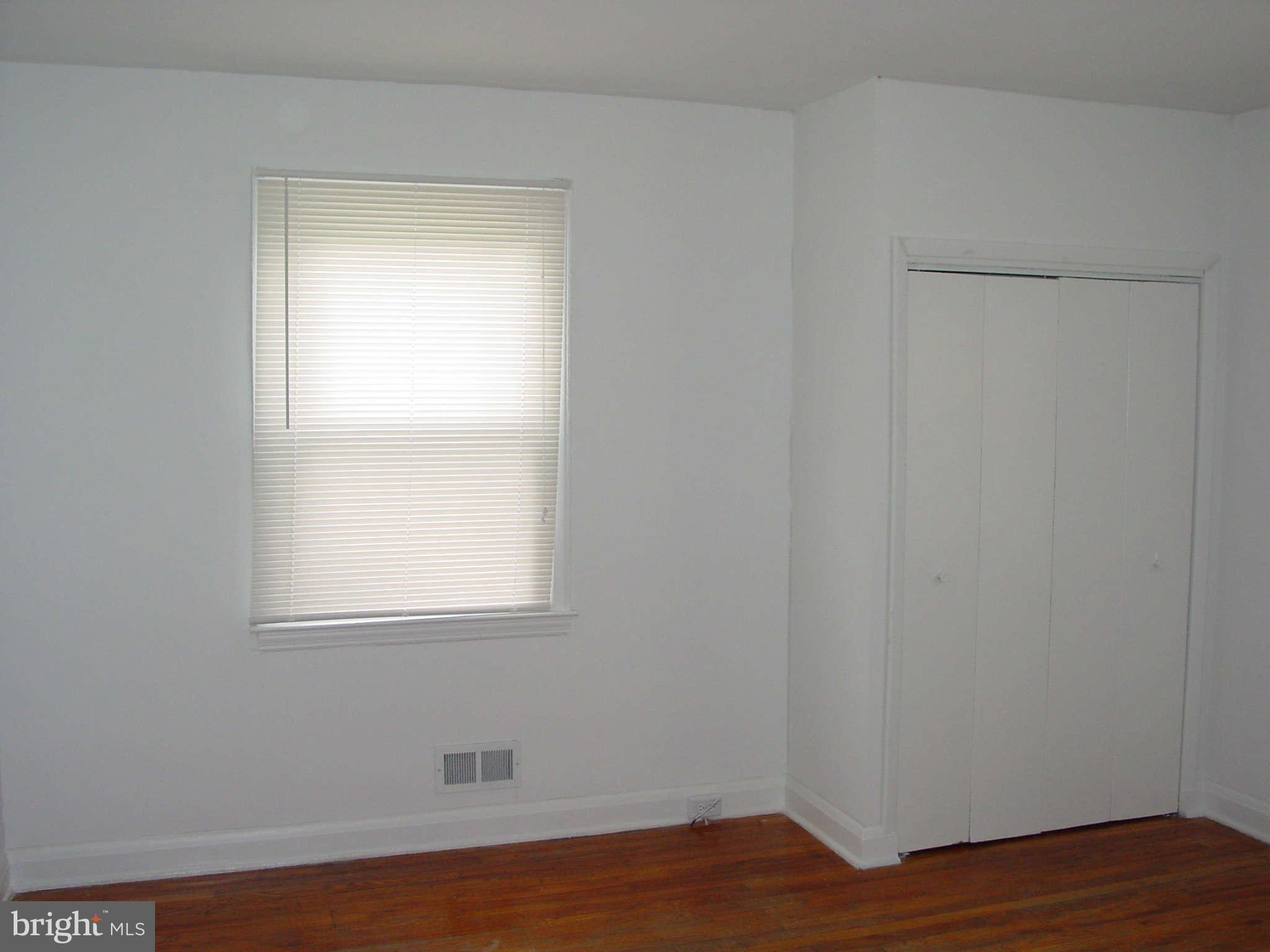 7903 Bon Air Road Baltimore, MD 21234 - Photo 9 of 17 a view of an empty room with wooden floor and a window