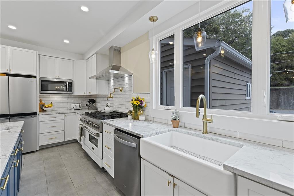 103 Main Street Ambridge, PA 15003 - Photo 15 of 49 a kitchen with a sink white cabinets and white appliances