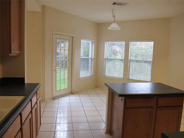 a view of a kitchen from the hallway with windows
