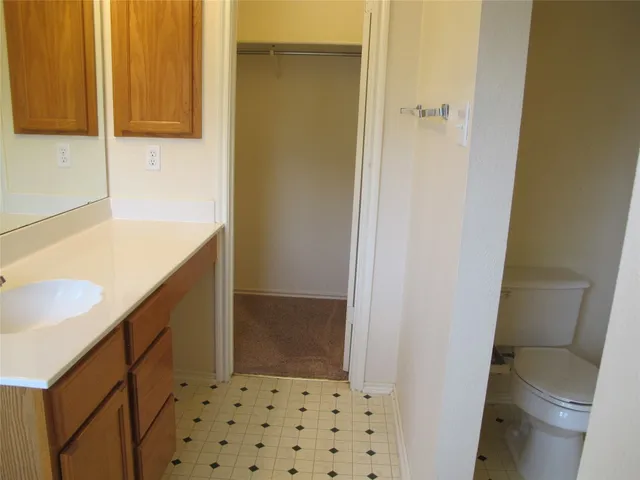 a bathroom with a granite countertop sink and a window