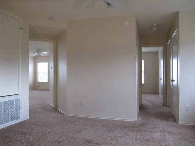 a white house with a big yard and large trees