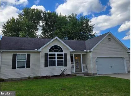 a front view of a house with a garden and yard