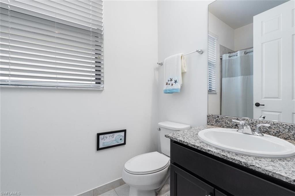 5586 Useppa Drive Ave Maria, FL 34142 - Photo 15 of 30 a bathroom with a granite countertop toilet a sink and a mirror