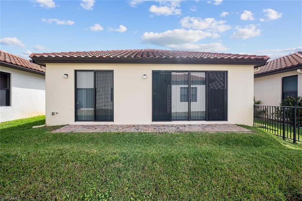 5586 Useppa Drive Ave Maria, FL 34142 - Photo 18 of 30 a front view of a house with a garden and yard