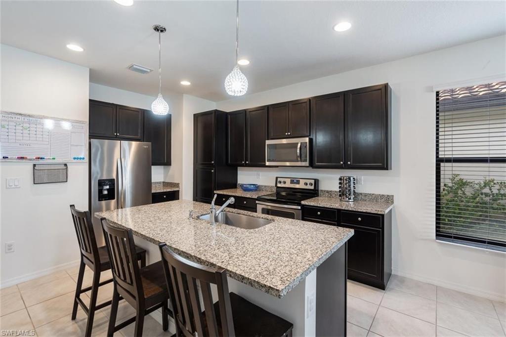 5586 Useppa Drive Ave Maria, FL 34142 - Photo 4 of 30 a kitchen with granite countertop kitchen island cabinets and stainless steel appliances