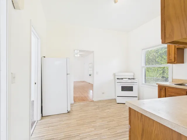 a kitchen with granite countertop a stove a sink and a refrigerator
