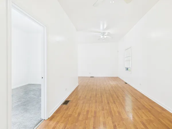 a view of a big room with wooden floor and fan
