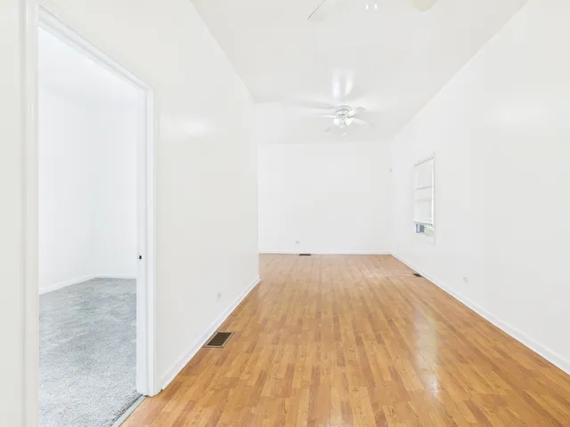 a view of a big room with wooden floor and fan