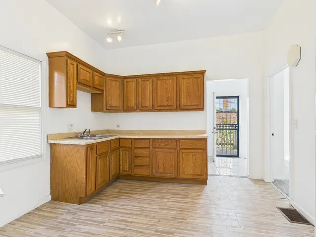 a kitchen with stainless steel appliances granite countertop a sink and cabinets with wooden floor