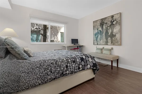 a bedroom with a bed and painting on the wall