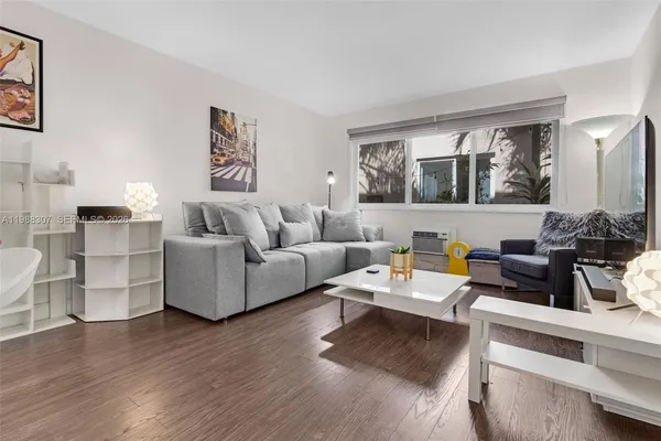 a living room with furniture wooden floor and wall painting