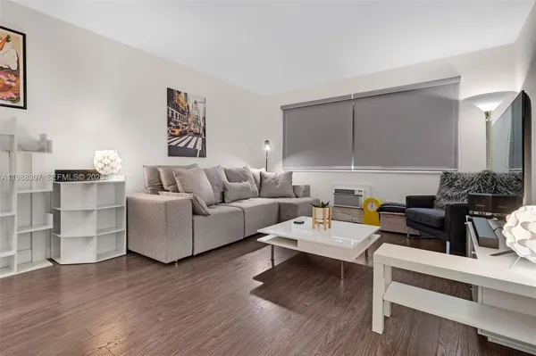 a living room with furniture wooden floor and a lamp