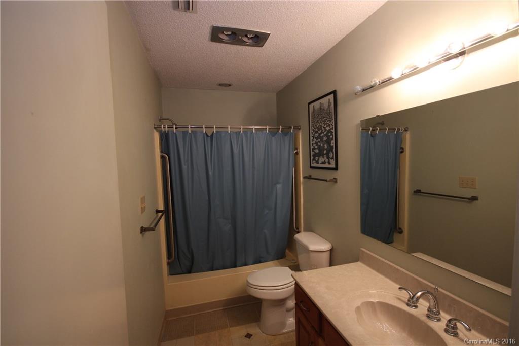 33 Old Post Road, Unit 33 Lake Wylie, SC 29710 - Photo 10 of 15 a bathroom with a sink a toilet a mirror and shower curtain