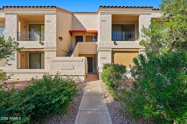 a view of a house with a small yard and a fountain