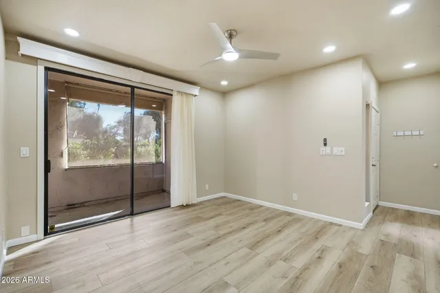 an empty room with wooden floor and windows