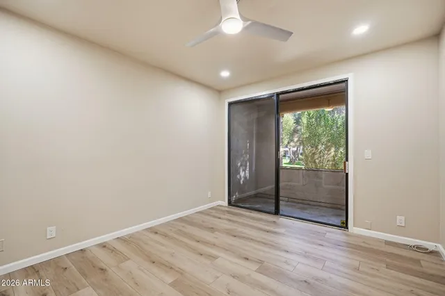 an empty room with wooden floor and sliding door