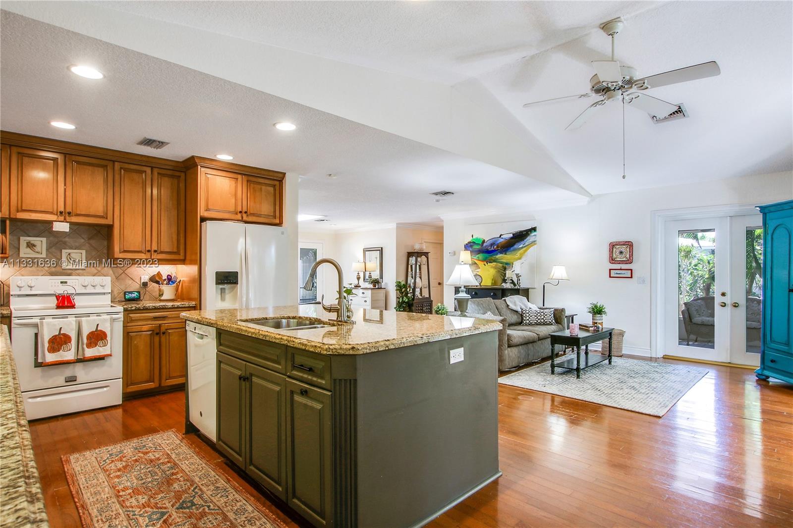 361 Zenith Lane Juno Beach, FL 33408 - Photo 21 of 36 a kitchen with stainless steel appliances granite countertop a sink stove and wooden floor