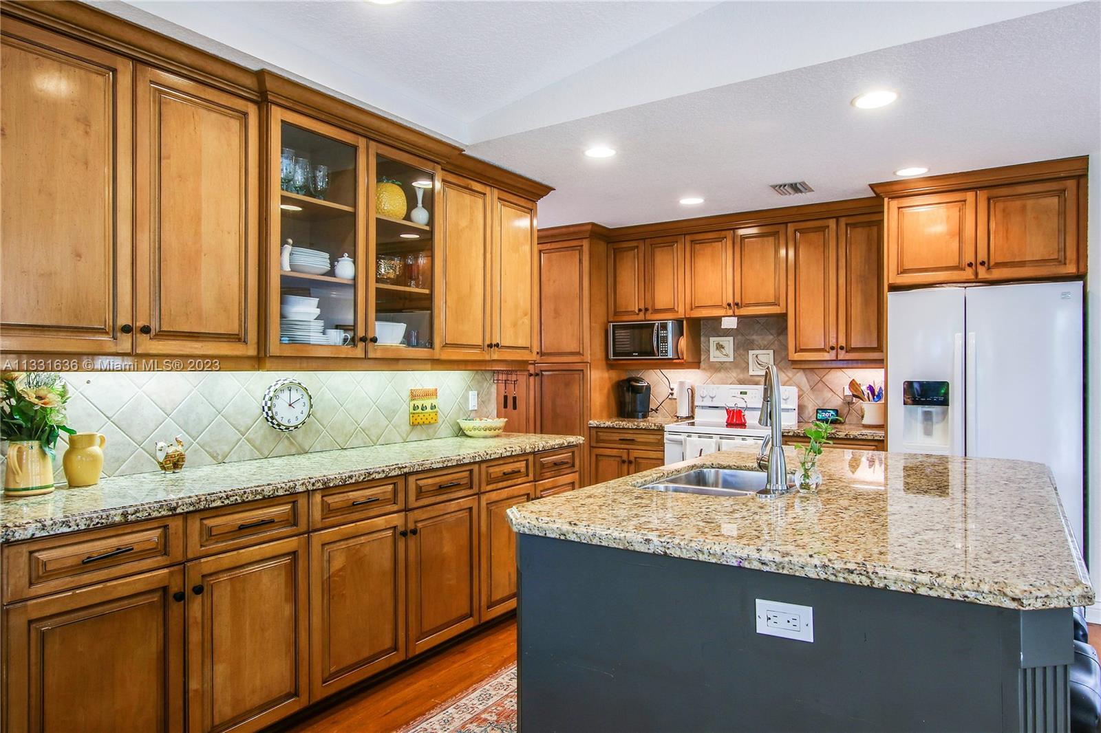 361 Zenith Lane Juno Beach, FL 33408 - Photo 22 of 36 a kitchen with stainless steel appliances granite countertop a sink stove and cabinets