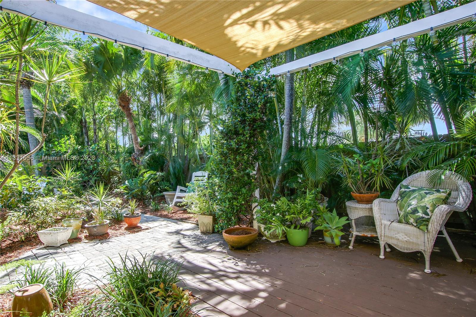 361 Zenith Lane Juno Beach, FL 33408 - Photo 28 of 36 a view of a chair and tables in the patio next to a yard