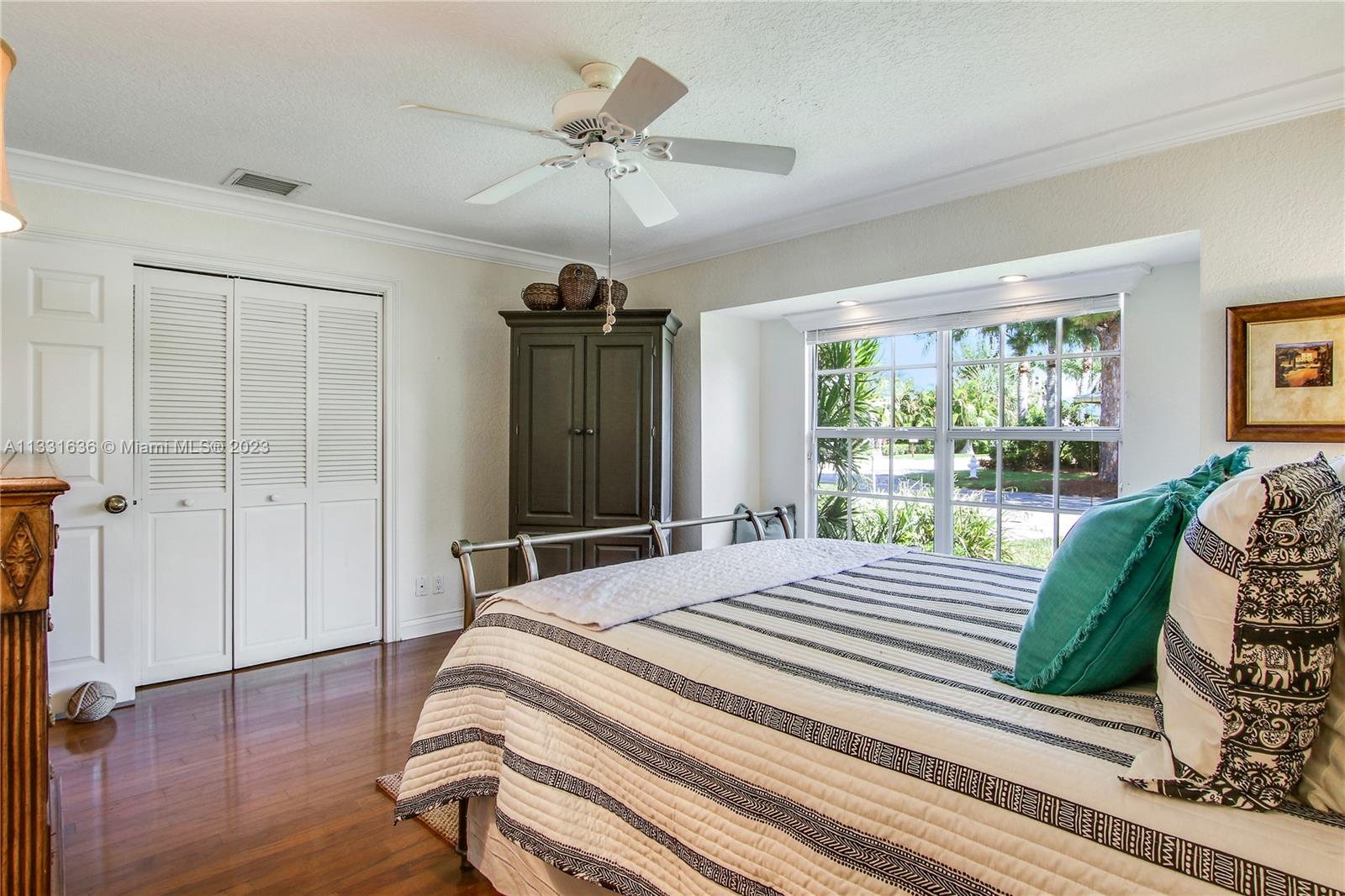 361 Zenith Lane Juno Beach, FL 33408 - Photo 10 of 36 a spacious bedroom with a bed a dresser and a large window