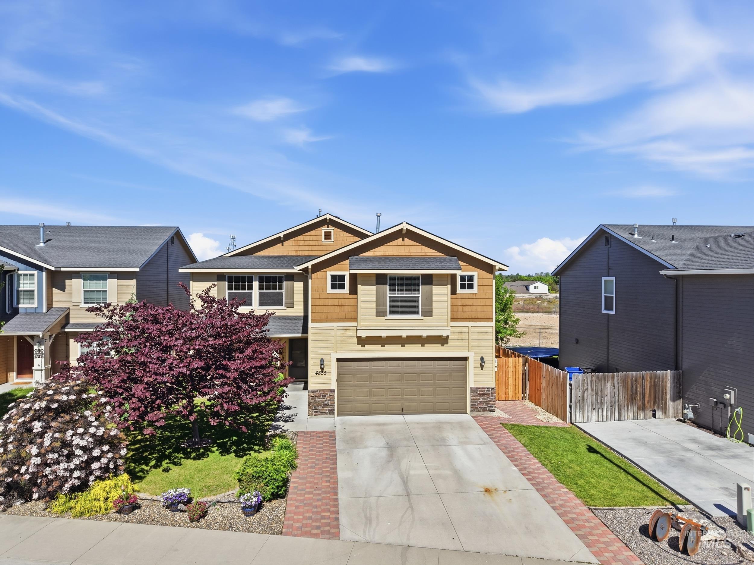 4855 South Chex Way Boise, ID 83709 - Photo 44 of 47 Multi-story residence featuring a two-car garage, stone façade accents, and an established front yard with mature landscaping
