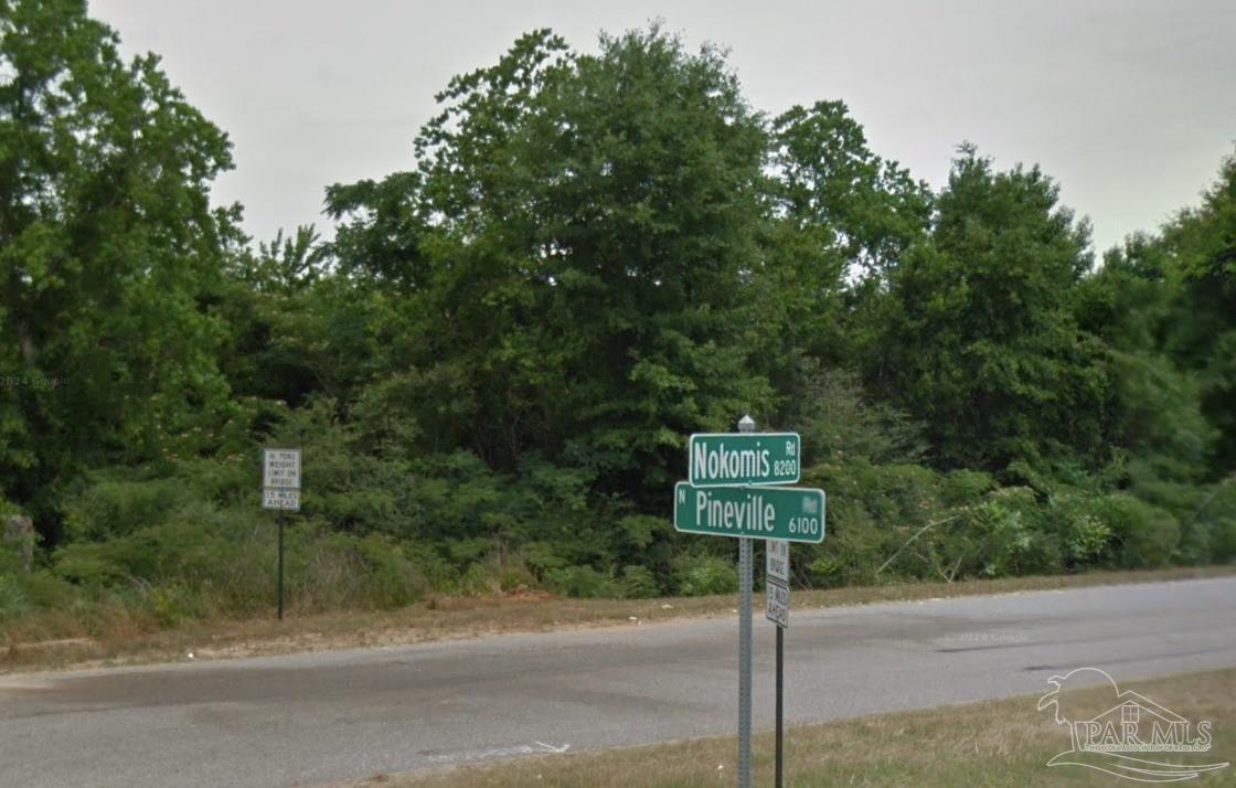 8300 Nokomis Road McDavid, FL 32568 - Photo 3 of 6 a street sign on a sidewalk next to a road