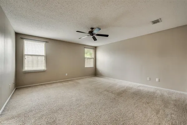 a view of an empty room and a ceiling fan window