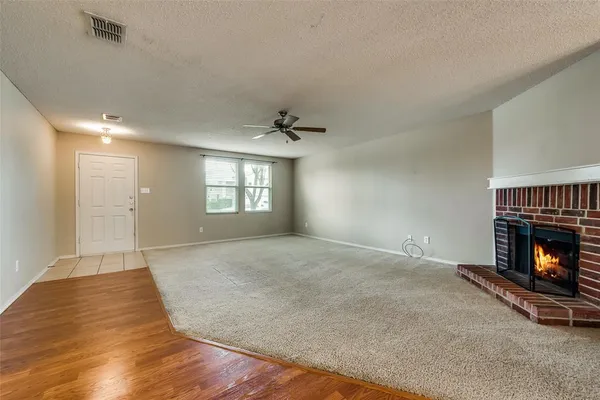 an empty room with windows and fireplace
