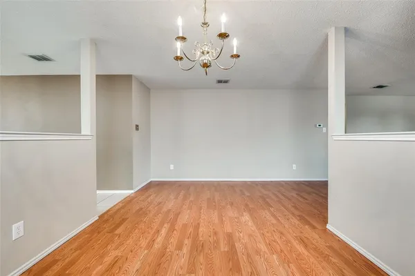a view of a room with wooden floor and chandelier