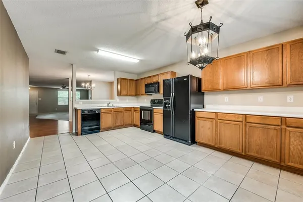 a large kitchen with stainless steel appliances granite countertop a refrigerator and a sink