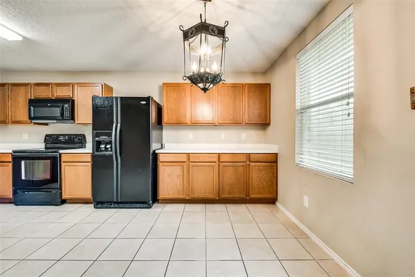 a kitchen with stainless steel appliances granite countertop a refrigerator a stove and a sink