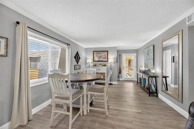 a living room with furniture kitchen view and a large window