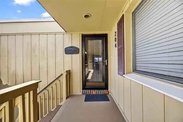 a view of a livingroom with a chair and front door
