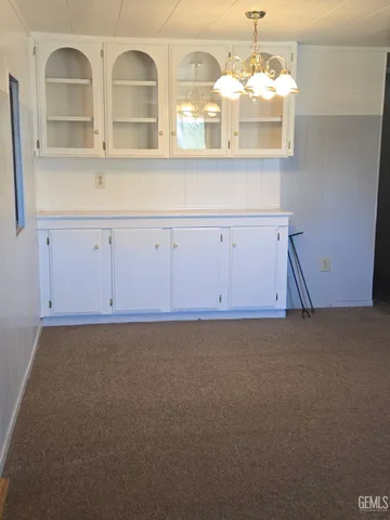 a view of kitchen cabinets and chandelier